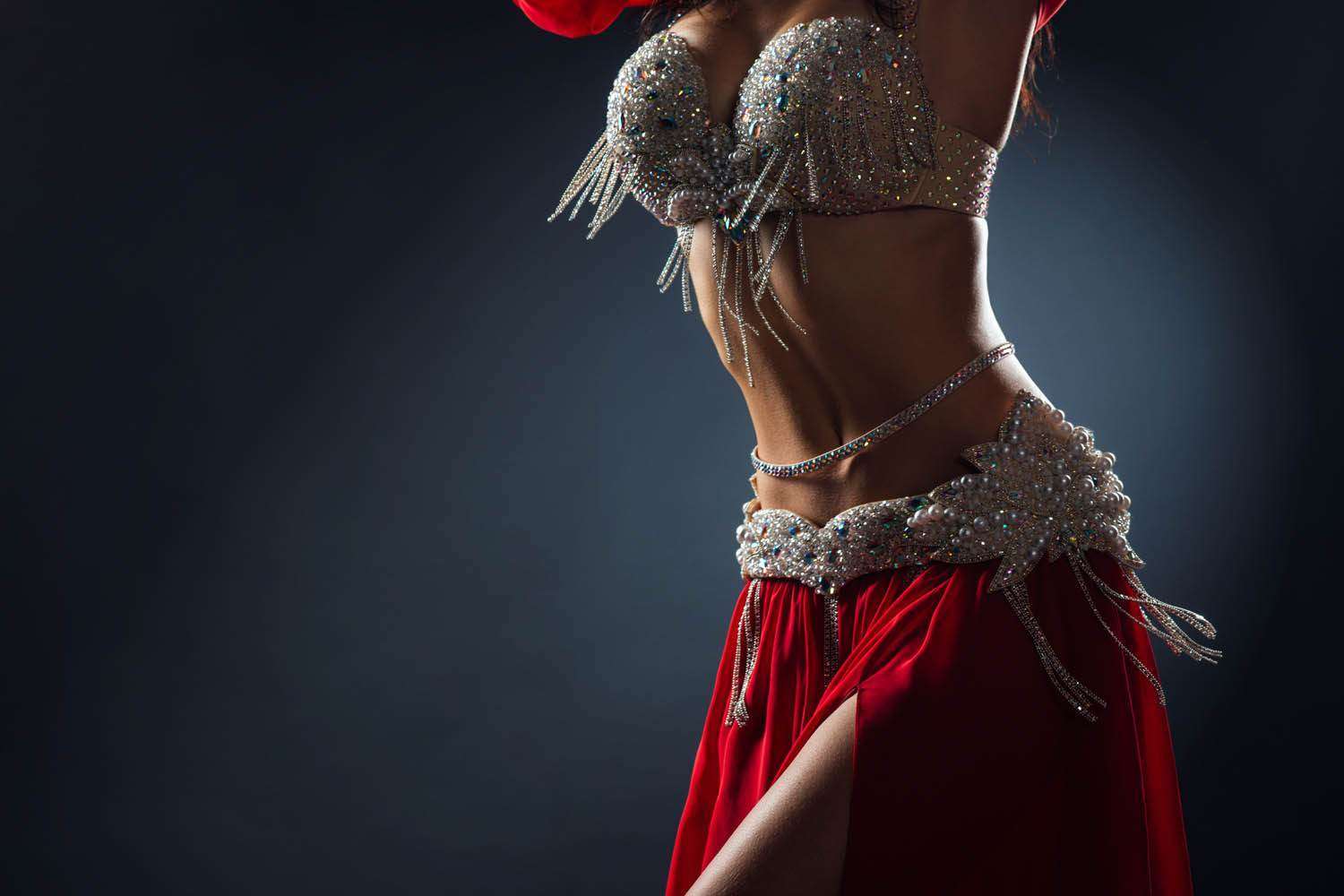 Beautiful belly dance of a girl in a red decorated ethnic dress